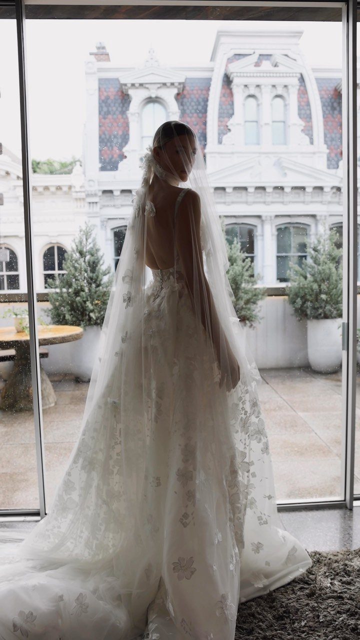 Woman in a white lace wedding dress wearing a long sheer tulle veil.