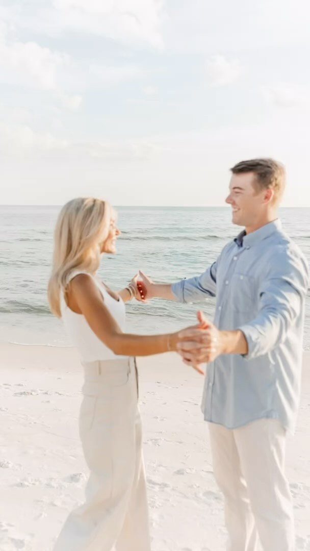 Man in light blue shirt and white pants on a sandy beach