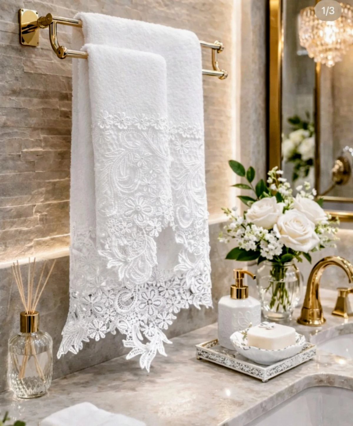 White ornate lace towel hanging on a gold bar in a luxury bathroom.