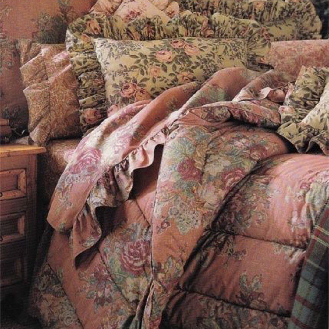 Floral patterned bed linens with a ruffled comforter and matching pillows on a bed.