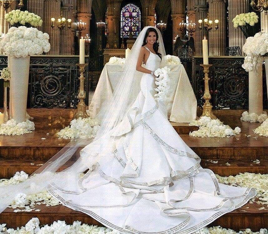 Eva Longoria in a white wedding gown with silver trim and a long veil.