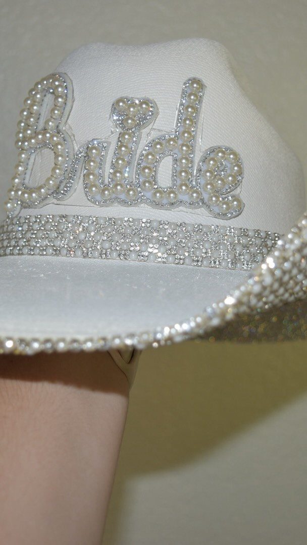 White bridal cowboy hat featuring pearl Bride lettering and a rhinestone band.