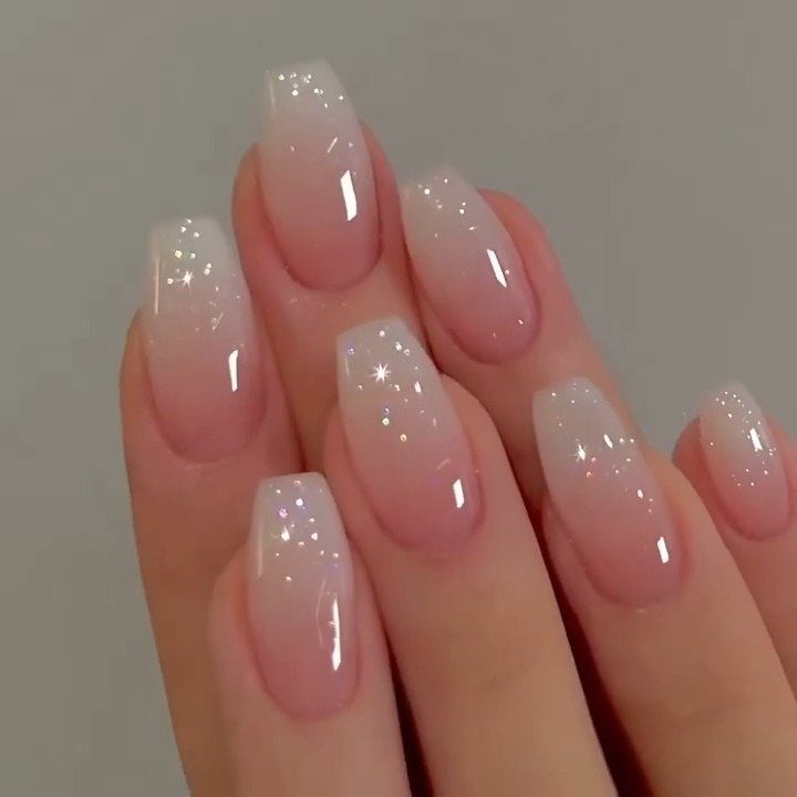 Almond-shaped nails with a soft milky white and sheer pink gradient glossy finish.