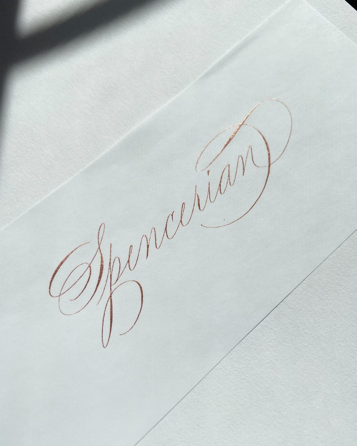 Spencerian calligraphy written in copper ink on white textured paper.