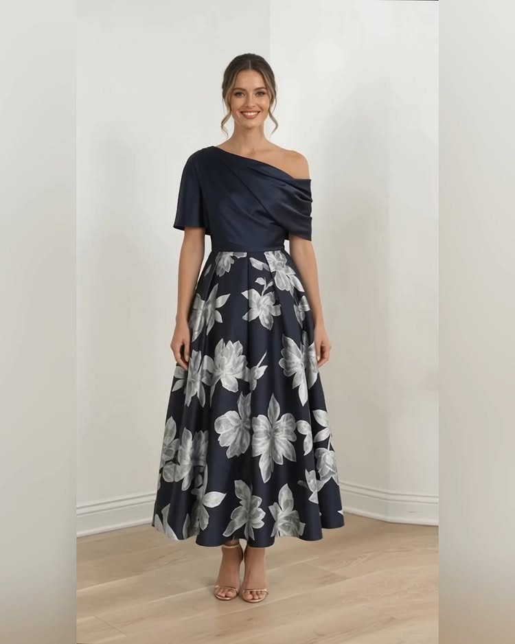 Woman in a navy one-shoulder midi dress with a silver floral print skirt.