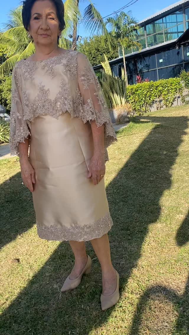 Older woman in a champagne lace wedding guest dress and matching pumps outdoors.