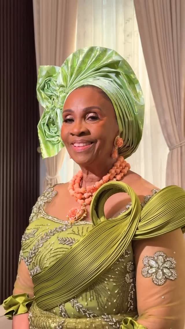 Older woman in lime green traditional Nigerian wedding attire with a matching gele headtie.