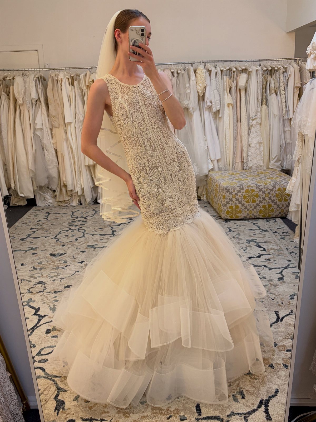 Woman wearing a mermaid wedding dress with a beaded top and tiered tulle skirt