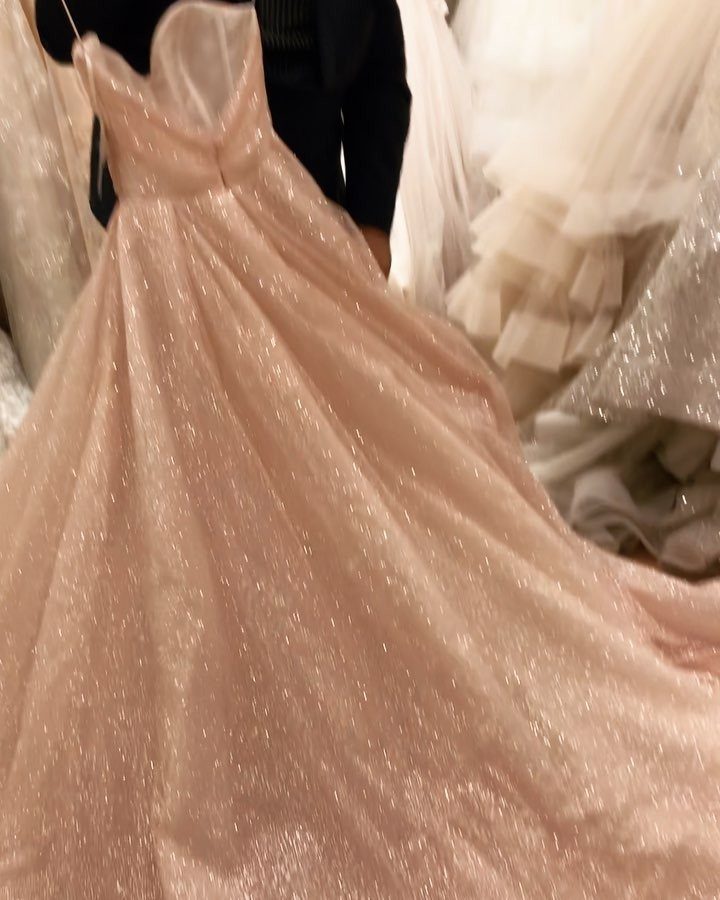 Champagne glittery ball gown wedding dress displayed in a bridal salon setting