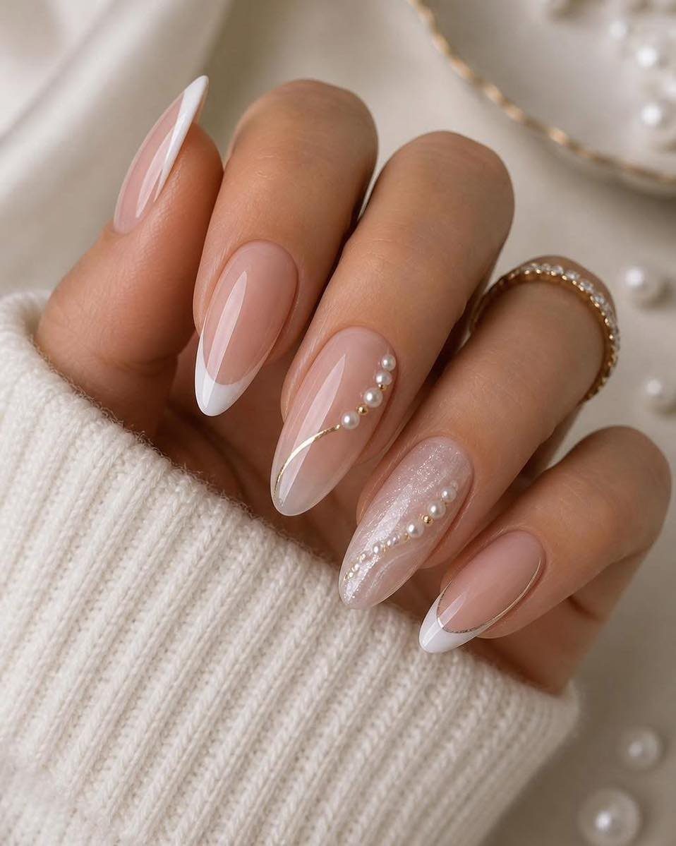 Almond shaped bridal nails with French tips and delicate white pearl accents