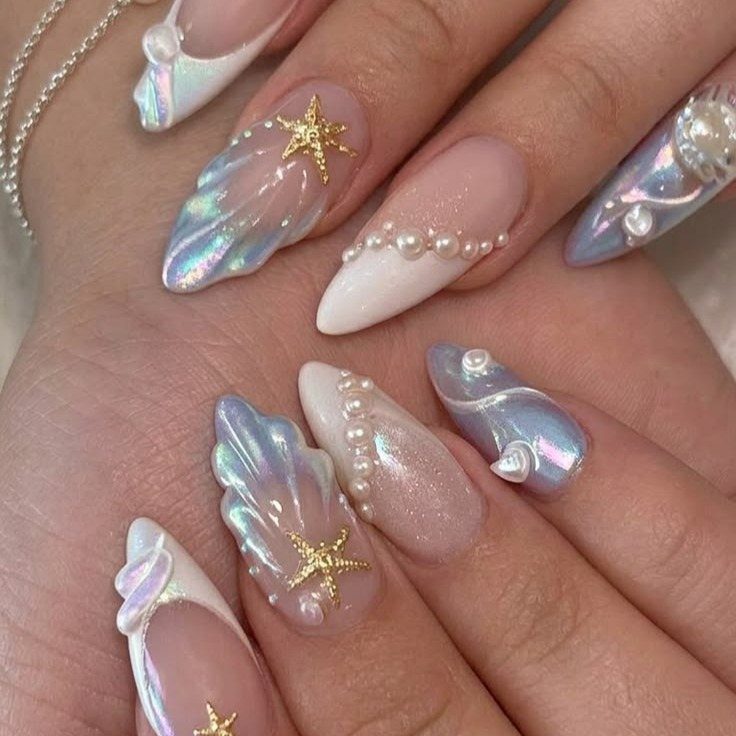 Iridescent white and blue almond nails with gold starfish and pearl accents.