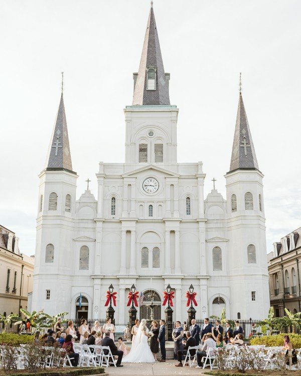 White cathedral with spires serving as a wedding venue for an outdoor ceremony.