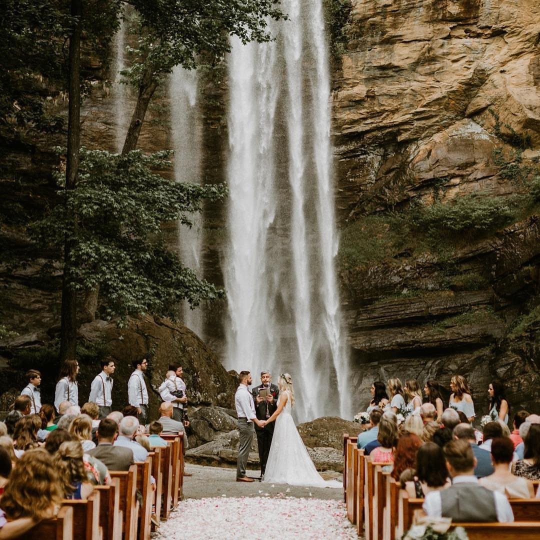 Wedding ceremony with a bride and groom standing before a massive cascading waterfall.