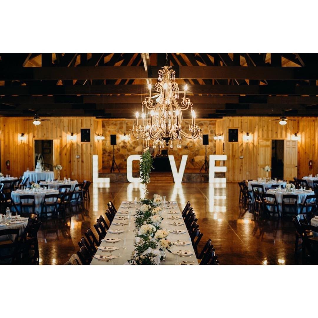 Rustic wedding venue interior with a large chandelier and white LOVE letters.