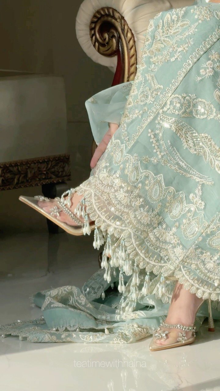 Mint green embroidered pastel outfit with silver high heels on a person.