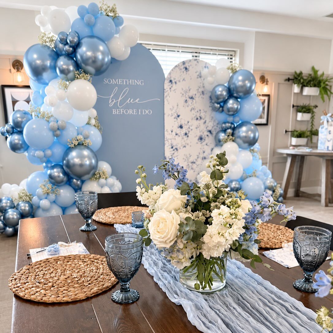 Blue glassware and a light blue runner on a wooden wedding table setting.