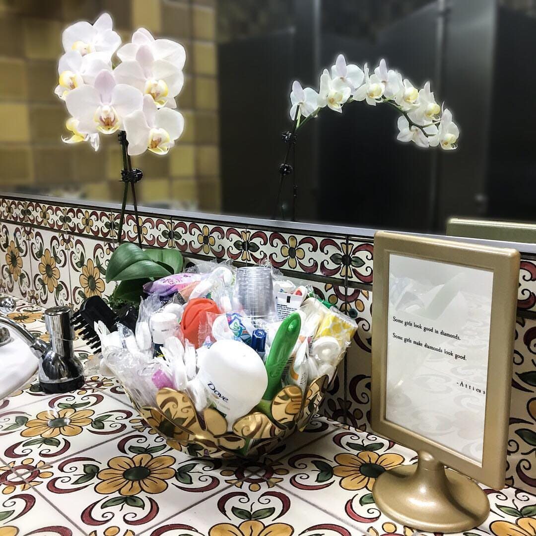 Gold decorative bowl with toiletries on a patterned tile bathroom counter.