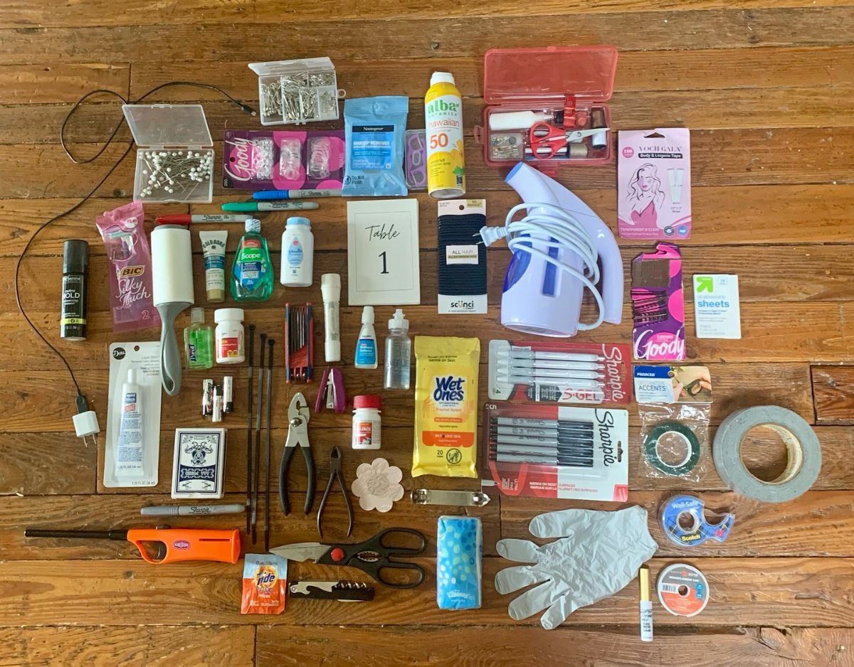 Emergency wedding kit supplies including a steamer, tools, and first aid on wooden floor