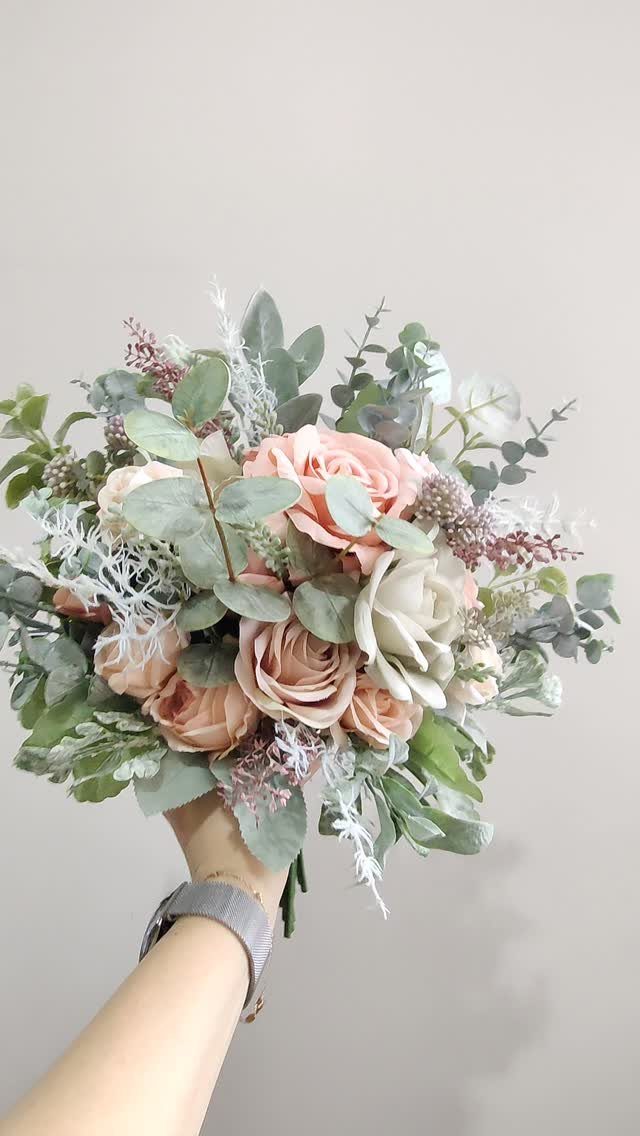 Bridal bouquet with dusty rose roses and sage green eucalyptus leaves.