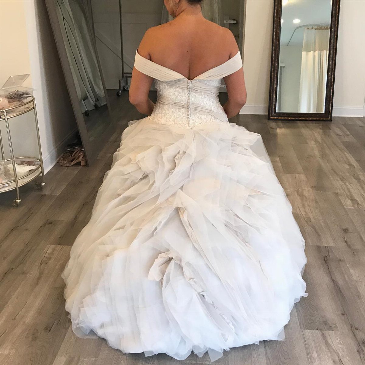 Woman wearing a white wedding dress with a voluminous ruffled ballroom bustle
