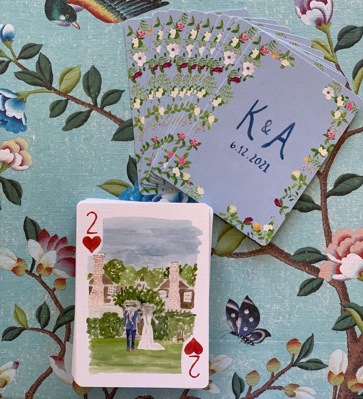 Custom wedding playing cards with a watercolor couple illustration and personalized blue backs.