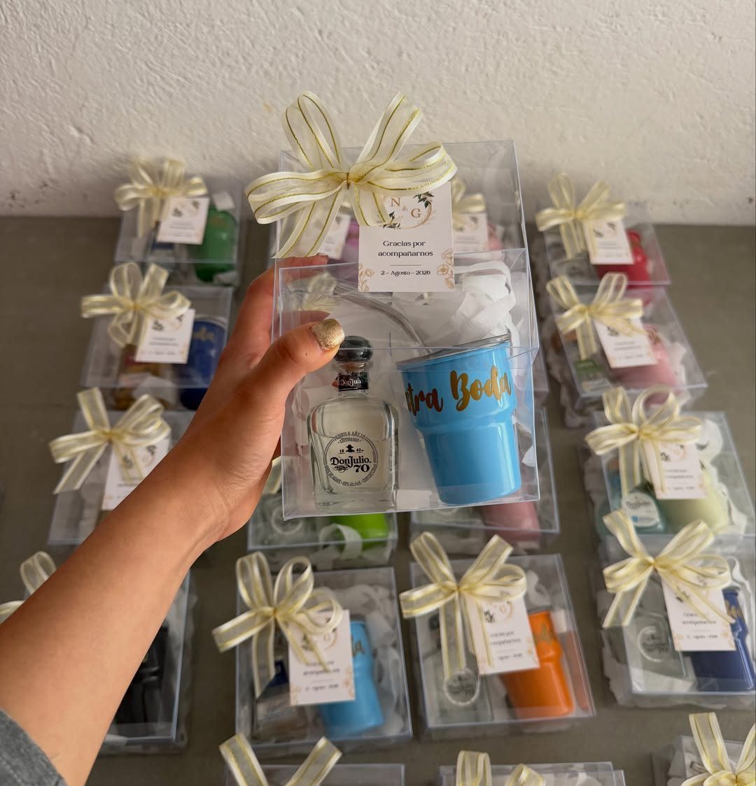 Mini cocktail kit with a small liquor bottle and blue tumbler in a gift box.