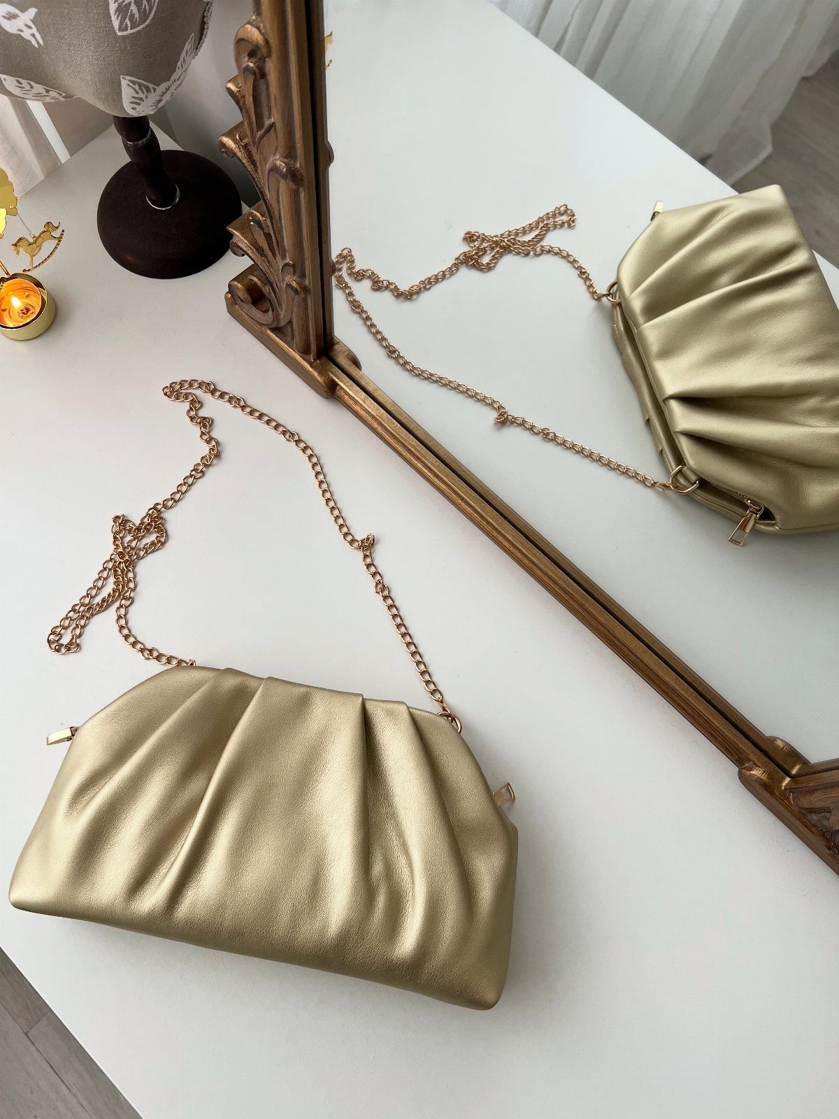 Gold pleated faux leather clutch bag with a thin gold chain strap.