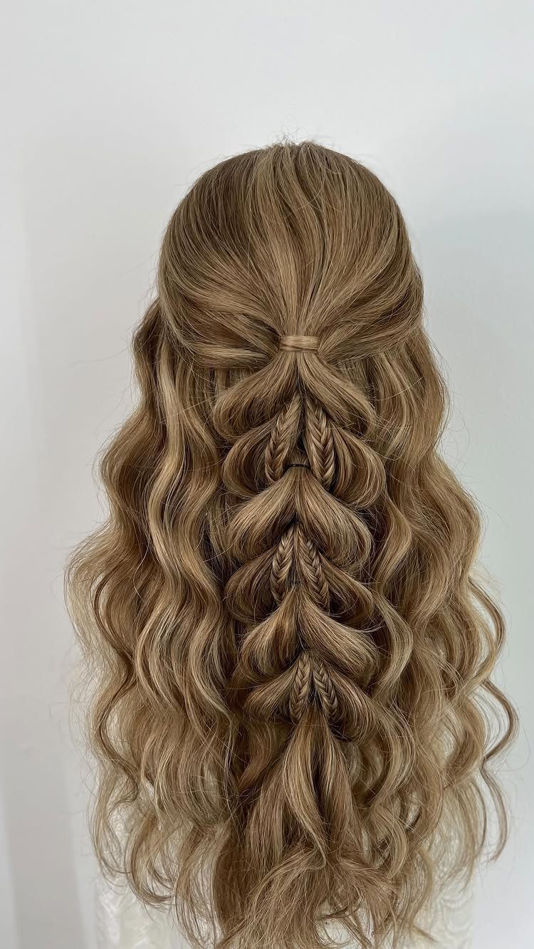 Intricate braided half-updo on long wavy light brown hair seen from behind