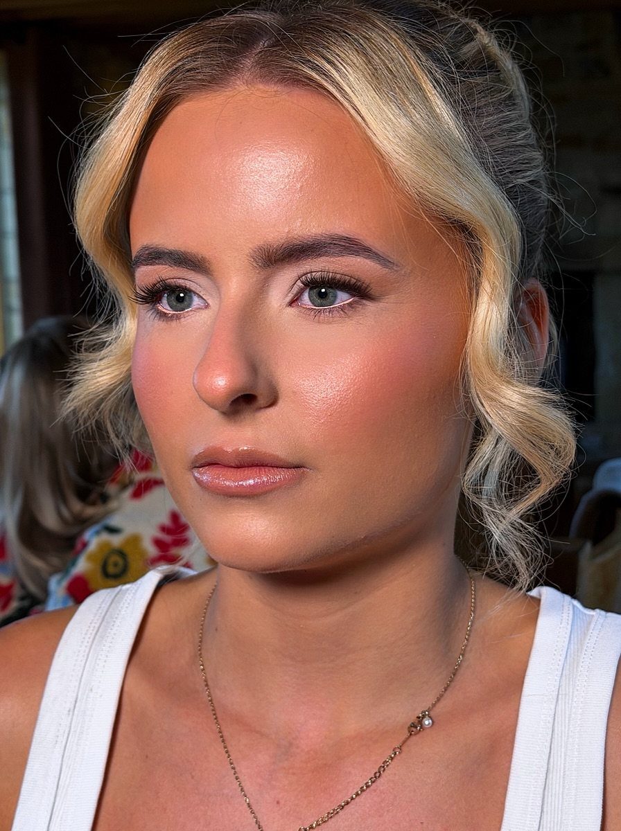 Woman with blonde hair wearing full glam makeup and long dark lash extensions.