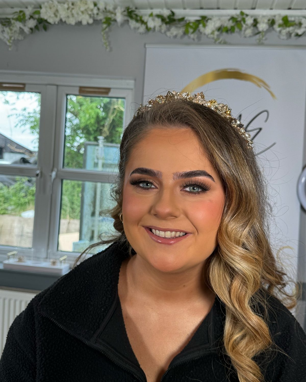 Woman with smoky shimmer eyeshadow and a gold tiara smiling for the camera