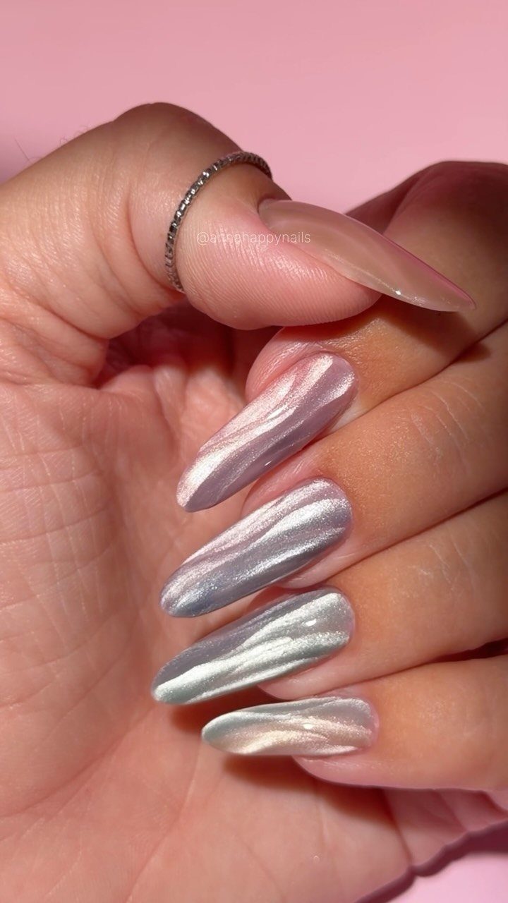 Silver metallic almond-shaped nails with a shimmering liquid effect on a hand.