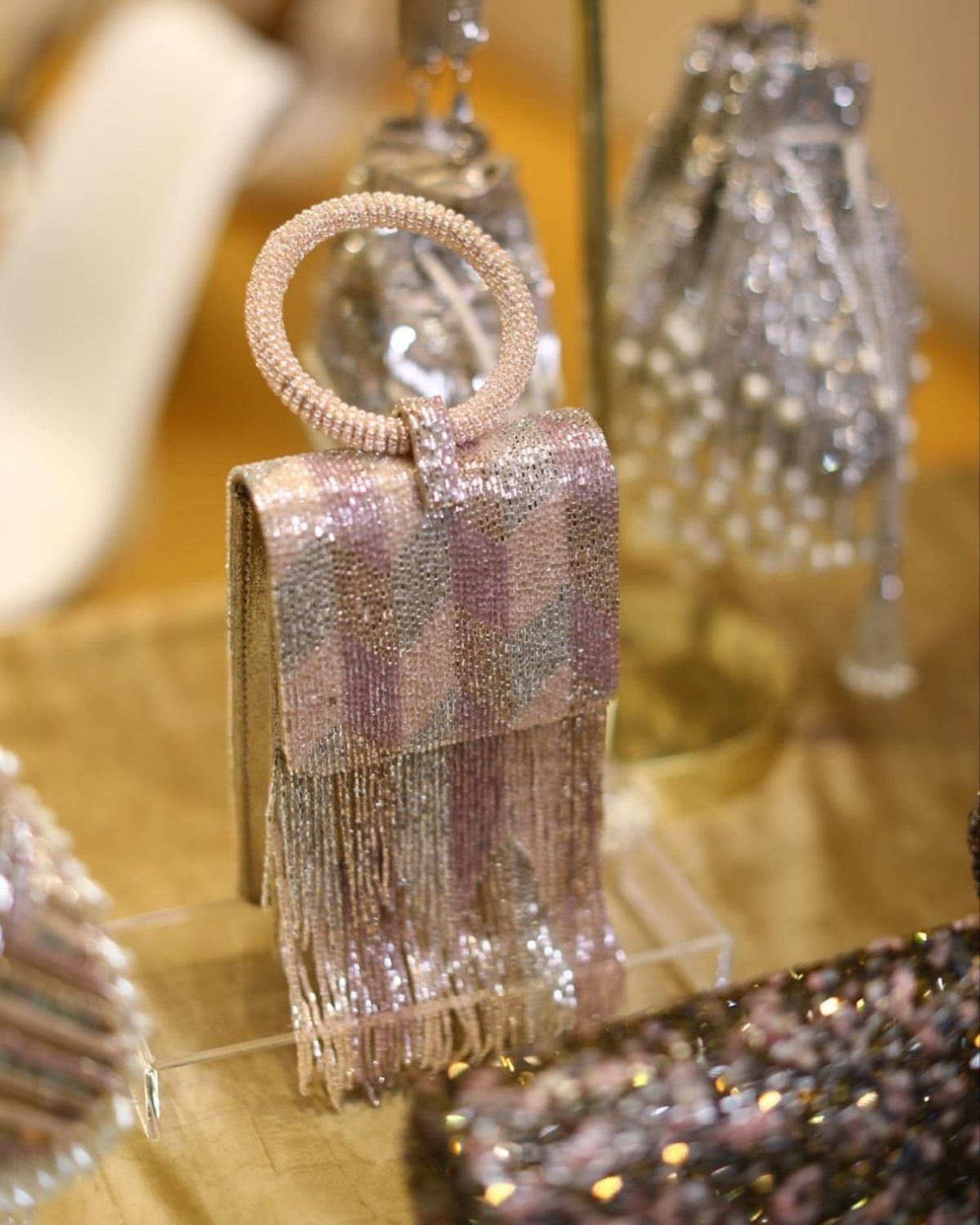 Beaded handbag with pink checkered pattern and long shimmering beaded fringe.