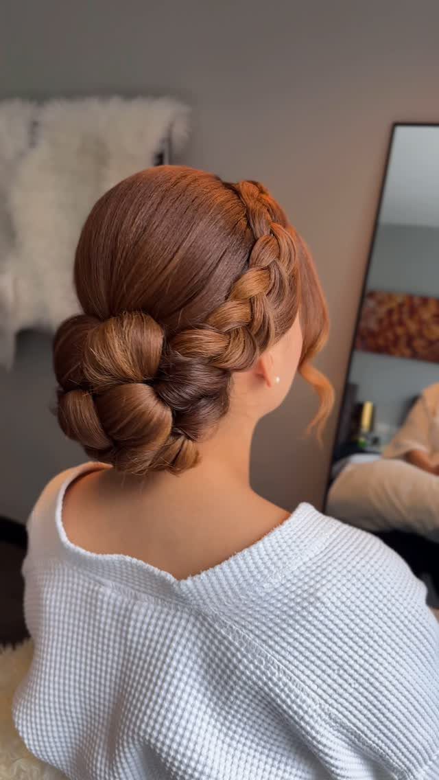 Intricate braided updo with a low bun on a woman with brown hair.