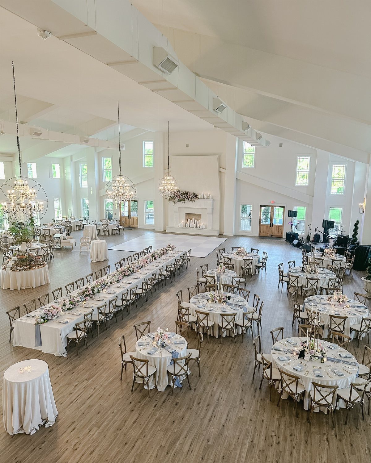 Wedding reception hall layout with round and long banquet tables on wooden floors.