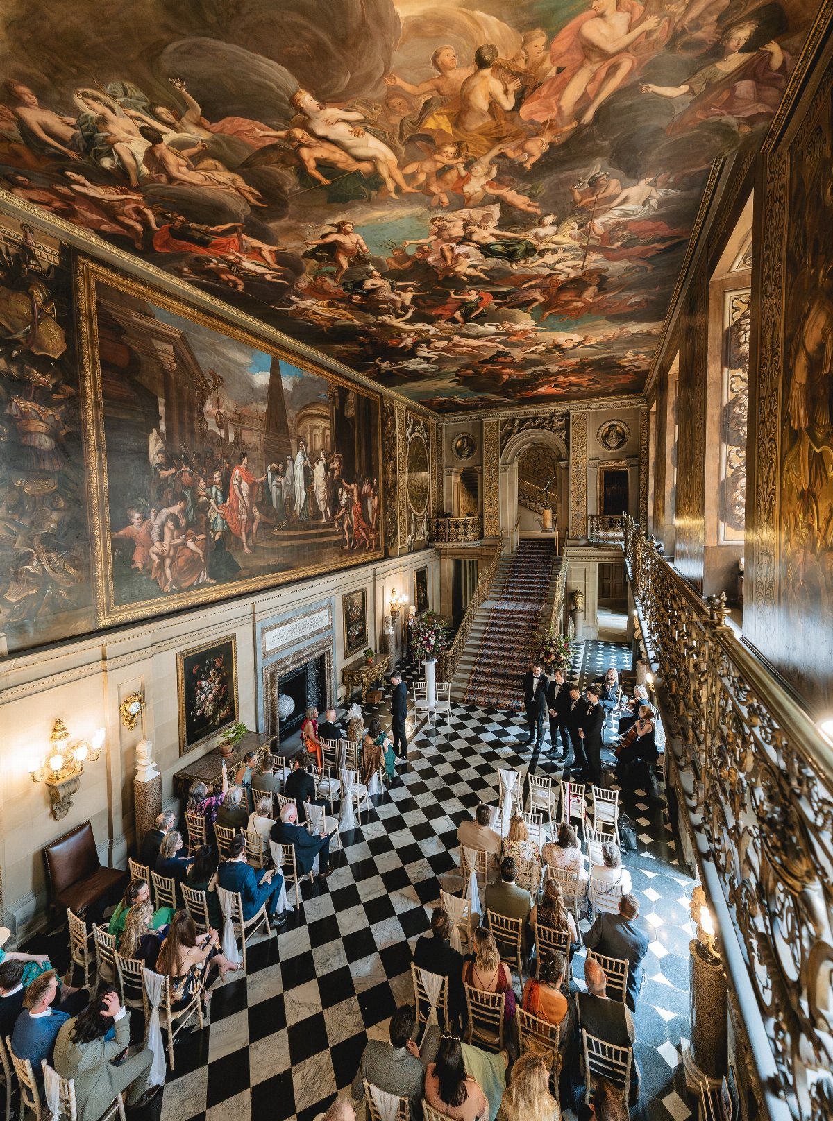 Grand hall with checkered floors and ceiling fresco set up for a wedding ceremony.
