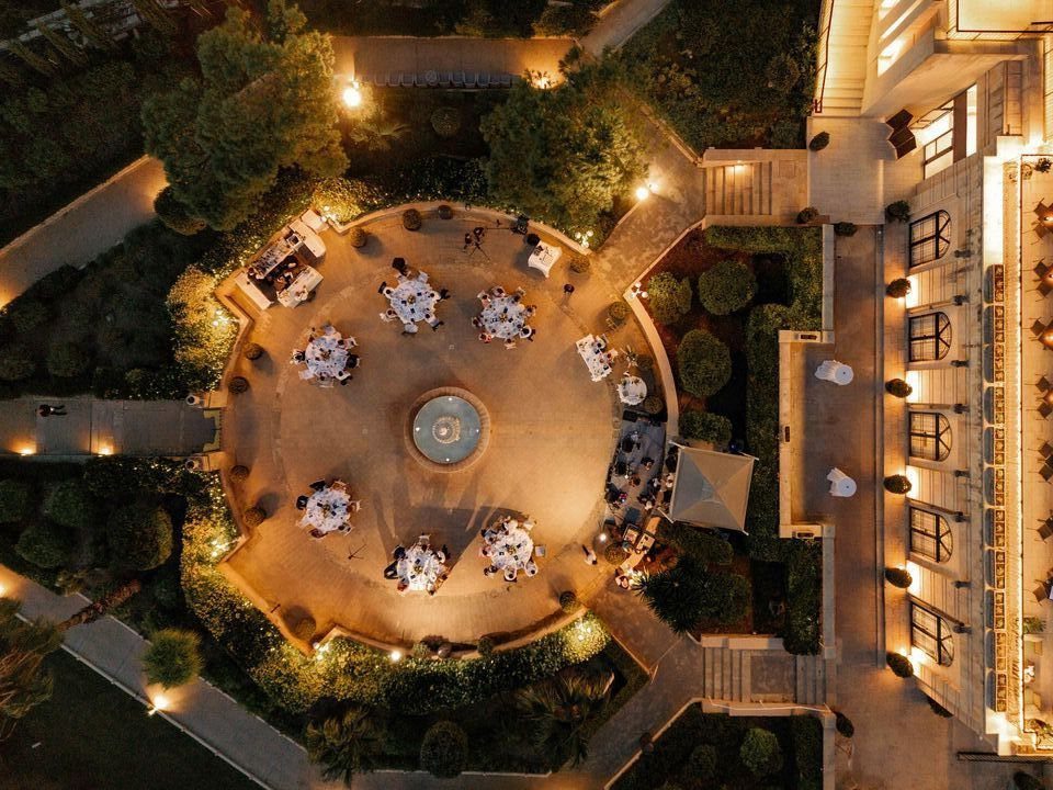 Circular outdoor courtyard with dining tables and a fountain at a luxury resort.