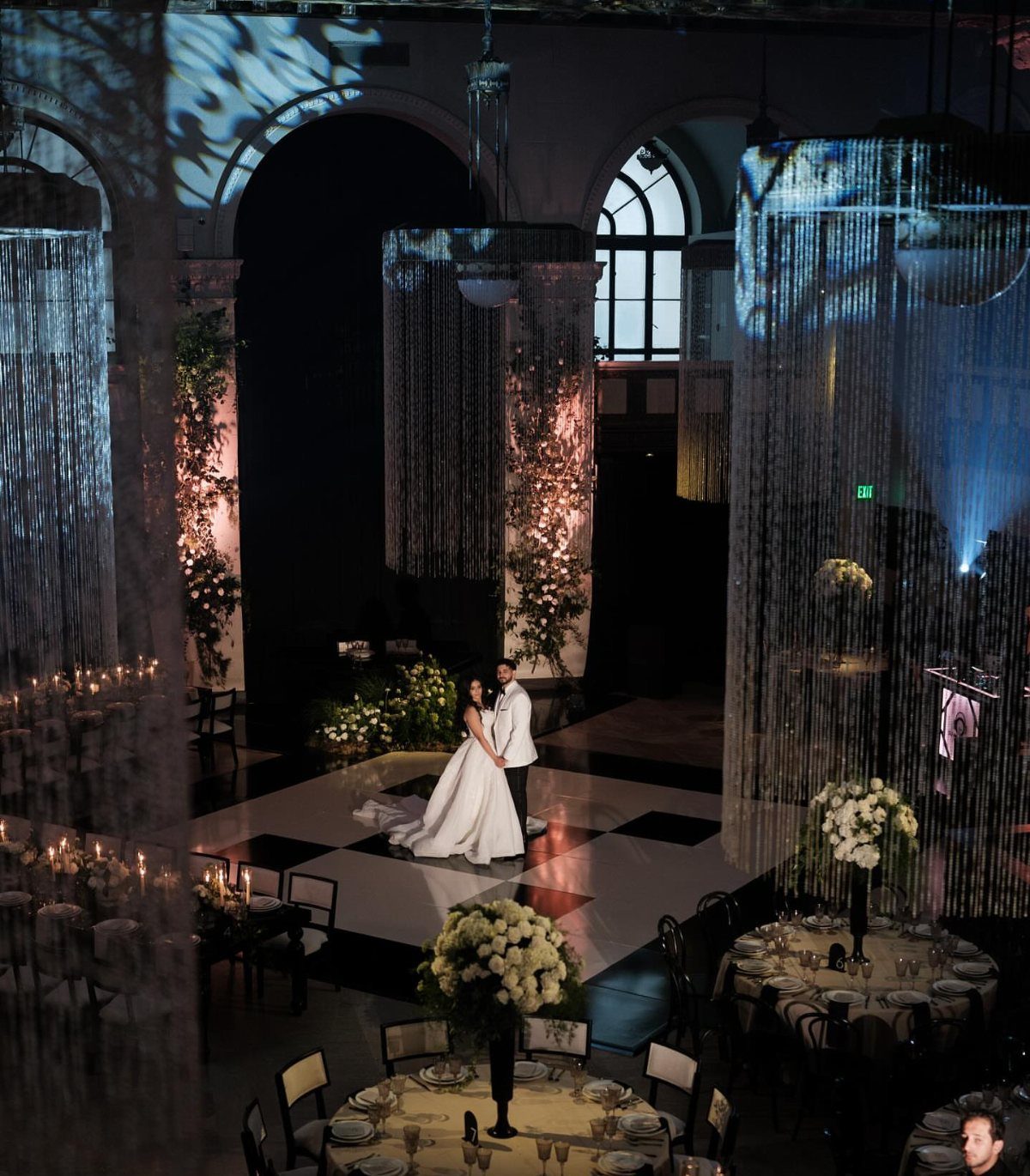 Bride and groom on a checkered dance floor in a grand architectural hall